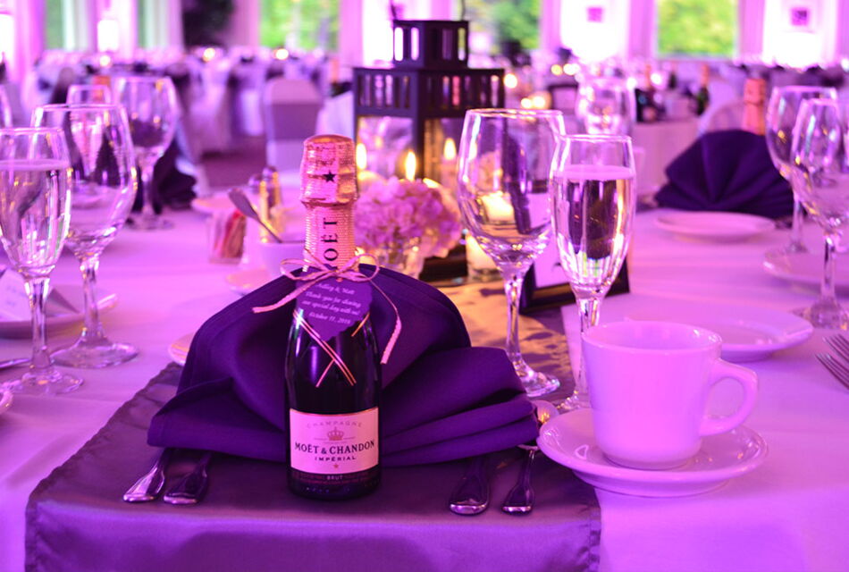 A place setting from a wedding with a mini bottle of champagne as a favor